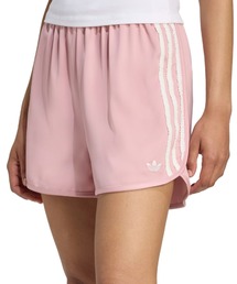 adidas（アディダス）の「adidas RUFFLE SHORTS / アディダス サテン ショーツ ラッフル スリーストライプス（その他パンツ・ピンク系）」
