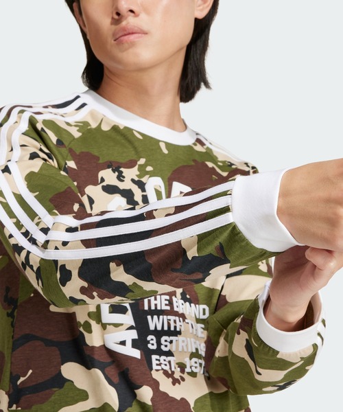 adidas（アディダス）の「カモ柄 長袖 カリTシャツ / ロンT