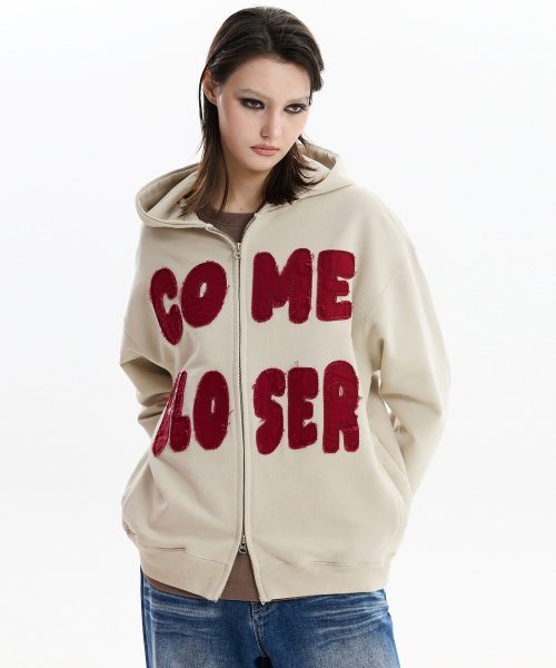 HOODHOOD(フッドフッド)の「COME CLOSER アプリケ フードパーカー ベージュ(パーカー・レディース・その他・1/2)」の1枚目の写真