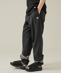 ELEY KISHIMOTO(イーリーキシモト)の「【ELEY KISHIMOTO×FILA】イーリーキシモト×フィラ トラックパンツ / ユニセックス / SM6FCU720(その他パンツ)」