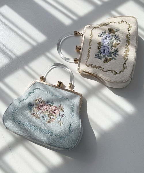 an another angelus(アンアナザーアンジェラス)の「クリアハンドルローズ刺繍がま口バッグ(ハンドバッグ・レディース・アイボリー/ライトブルー・FREE)」の1枚目の写真