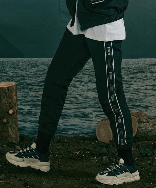 FCMM(エフシーエムエム)の「LOGO TAPE WINDBREAKER PANTS/ロゴテープウィンドブレーカーパンツ(その他パンツ・メンズ・グレー/ライトパープル/ブラック・MEDIUM/LARGE)」の2枚目の写真