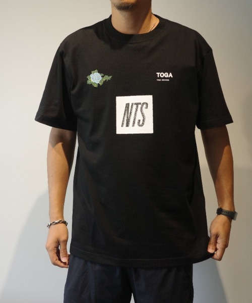 TOGA TOO(トーガトゥ)の「TOGA×NTS Logo print T-shirt TOGA×NTS(Tシャツ/カットソー・メンズ・ブラック/ホワイト・LARGE)」の1枚目の写真