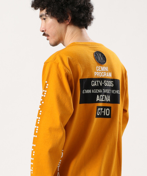 AVIREX(アヴィレックス)の「AVIREX/アヴィレックス/ 長袖 クルーネック Tシャツ マルチグラフィック/ L/S CREW NECK T-SHIRT MULTI GRAPHIC/ GT-10(Tシャツ/カットソー)」|マスタード