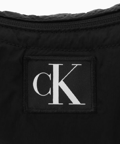 カルバンクライン　ボディバッグ ロゴプリント ホワイト・ブラック Calvin Klein（カルバン・クライン）の「ミドルクレセント