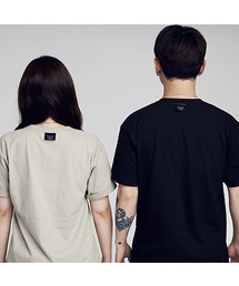 APOSTROPHE COMMA（アポストロフィコンマ）の「バックポイントラベル無地半袖Tシャツ（ブラック）（Tシャツ/カットソー）」