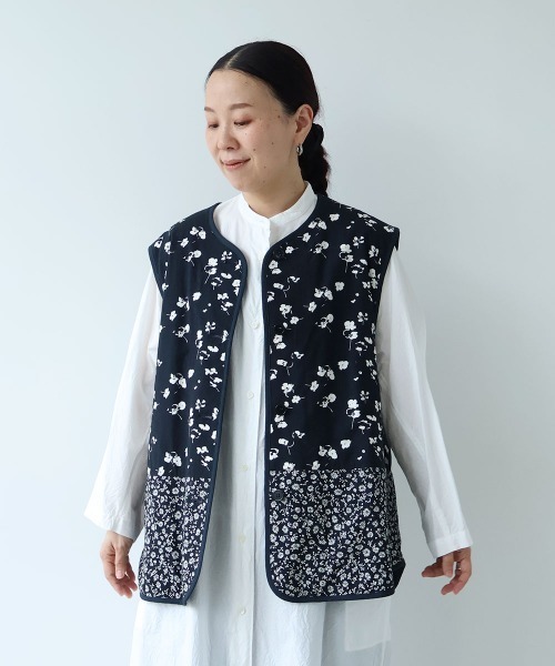 yuni(ユニ )の「小花pr x無地 中綿 reversible vest(ベスト・レディース・ネイビー/ダークネイビー・FREE)」の1枚目の写真