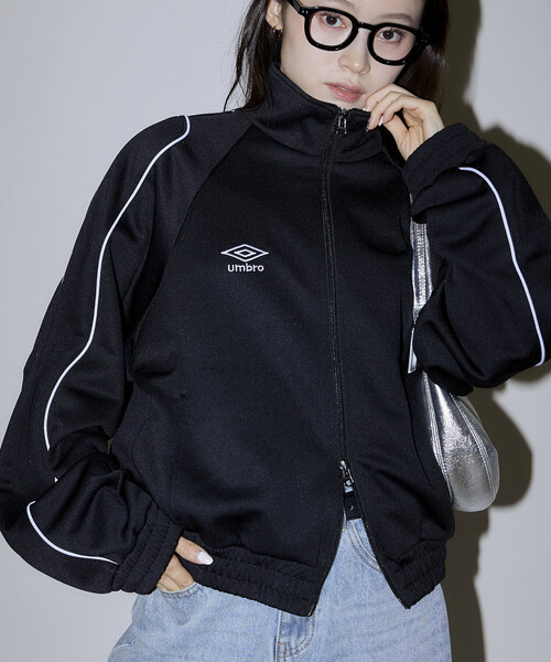 UMBRO(アンブロ)の「UMBRO × PUBLUX/アンブロ 別注 パイピング トラックジャケット 限定展開(ジャージ・レディース・ブラック/ナチュラル/ブラウン・フリ-)」の1枚目の写真