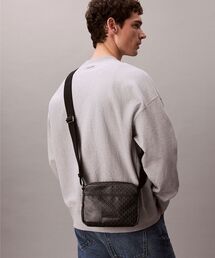 Calvin Klein（カルバン・クライン）の「クロスボディバッグ - エンブレムオールプリントコートキャンバスカメラバッグ（ショルダーバッグ）」