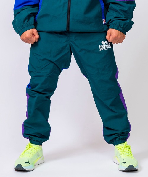LONSDALE（ロンズデール）の「LONSDALE/ロンズデール セットアップ対応可 ワンポイントロゴ リフレクタープリント 両脇ポケット オーバーサイズ 配色 裏起毛 保温 ウォームアップ トレーニング ナイロンワッシャーパンツ（その他パンツ・メンズ・パープル/グリーン/ブラック・M/L/LL）」の3枚目の写真