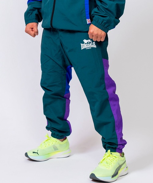 LONSDALE（ロンズデール）の「LONSDALE/ロンズデール セットアップ対応可 ワンポイントロゴ リフレクタープリント 両脇ポケット オーバーサイズ 配色 裏起毛 保温 ウォームアップ トレーニング ナイロンワッシャーパンツ（その他パンツ・メンズ・パープル/グリーン/ブラック・M/L/LL）」の4枚目の写真
