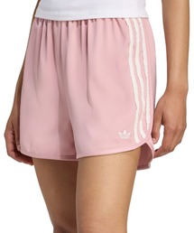 adidas（アディダス）の「adidas RUFFLE SHORTS / アディダス サテン ショーツ ラッフル スリーストライプス（その他パンツ・ピンク系）」