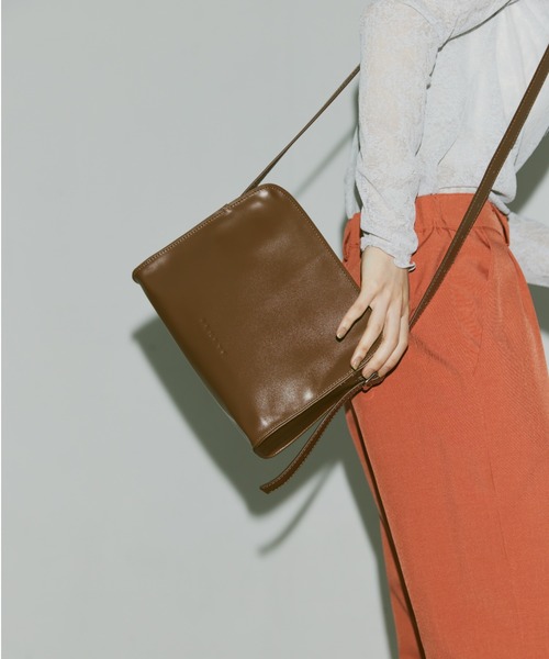 FEKETE(フェケテ)の「FEKETE LOGO VEGAN LEATHER SHOULDER BAG / フェイクレザーショルダーバッグ(ショルダーバッグ・メンズ・オレンジ/ブラウン/ブラック・FREE)」の1枚目の写真