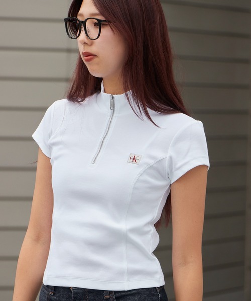 Calvin Klein(カルバン・クライン)の「Calvin Klein/カルバンクライン トップス - ハーフジップハイネックトップス SS WOVEN LABEL 2X2 BABY RIB ZIP MOCK NK クロップド丈 ショート コンパクト チビT ミニT タイト スリムフィット 胸ロゴ 半袖 レディース 2026年 夏 夏服(Tシャツ/カットソー・レディース・ホワイト/ブラック・S/M)」の1枚目の写真