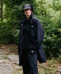 WHITE MOUNTAINEERING（ホワイトマウンテニアリング）の「White Mountaineering/ホワイトマウンテニアリング×UMBRO/アンブロ MULTI POCKET COAT コート（モッズコート・メンズ）」