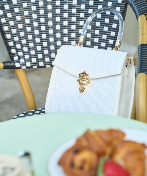 an another angelus(アンアナザーアンジェラス)の「フロント金具使いフェイクラフィアバッグ(ハンドバッグ・レディース・ブラック×ベージュ/オフホワイト・FREE)」の1枚目の写真