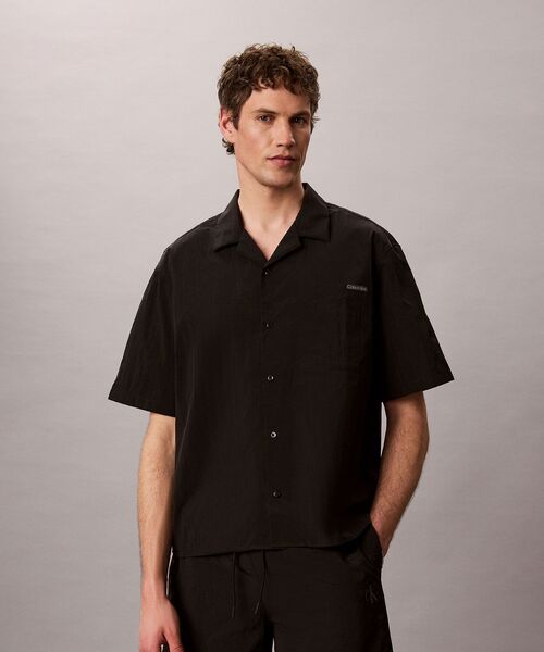 Calvin Klein(カルバン・クライン)の「ショートスリーブソリッドキャンプカラーシャツ(シャツ/ブラウス・メンズ・ブラック・M/L/S)」の1枚目の写真