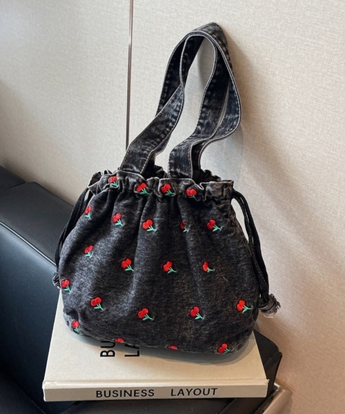 Doux Belle(ドゥーベル)の「チェリー柄 巾着風デニムバッグ(ハンドバッグ・レディース・インディゴブルー/ライトブルー/ブラック・FREE)」の1枚目の写真