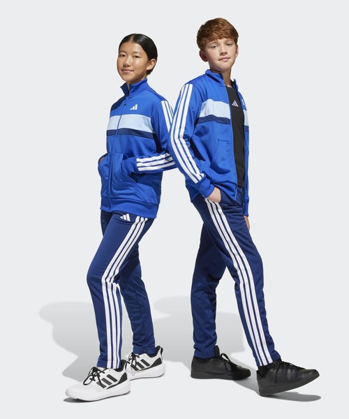 adidas(アディダス)の「シーズナル エッセンシャルズ Tiberio スリーストライプス トリコット トラックスーツ キッズ / ジャージ / アディダス adidas(ジャージ・キッズ・ブラック×グレー/ブラック×レッド/ブルー・130/140/150/160)」の1枚目の写真