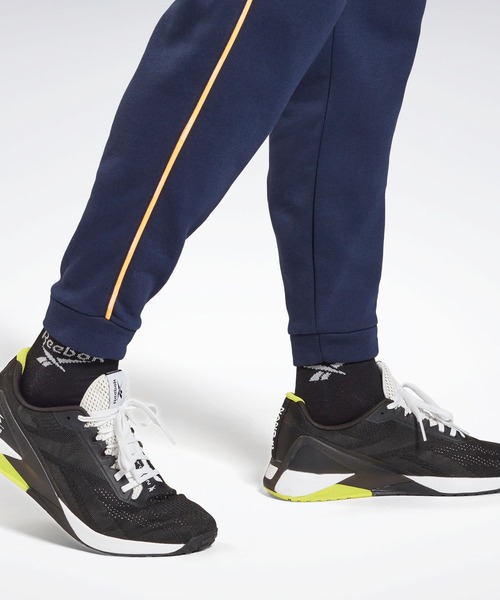 Reebok（リーボック）の「トレーニング エッセンシャルズ パイピング ジョガーズ / Training Essentials Piping Joggers（スウェットパンツ・メンズ・ブラック/ネイビー・XXX-LARGE/MEDIUM/LARGE/X-LARGE/SMALL/XX-LARGE/X-SMALL）」の3枚目の写真
