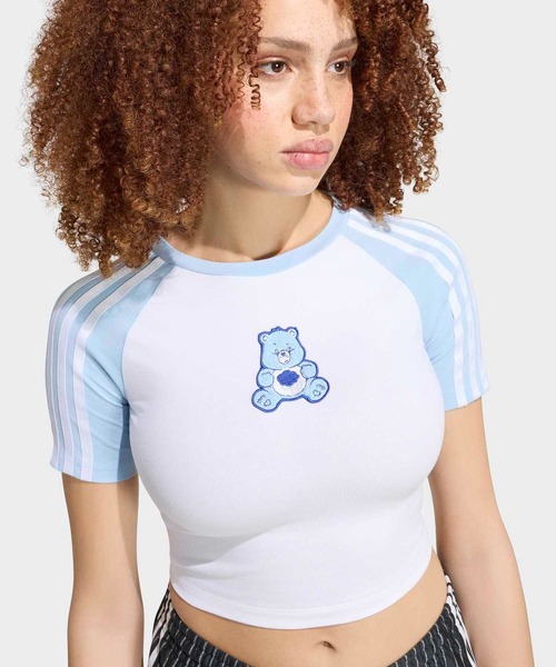 adidas(アディダス)の「ケアベア x アディダス ベビー半袖Tシャツ / アディダスオリジナルス adidas Originals(Tシャツ/カットソー・レディース・ホワイト・X-SMALL/X-LARGE/SMALL/MEDIUM/LARGE/XX-LARGE)」の1枚目の写真