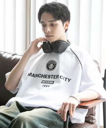 CORPUS　SELECT（コーパストーキョー）の「【Manchester City/マンチェスターシティー】エンブレムロゴワッペン ラグランショートスリーブデザインTシャツ 裾ドロスト（Tシャツ/カットソー・メンズ）」