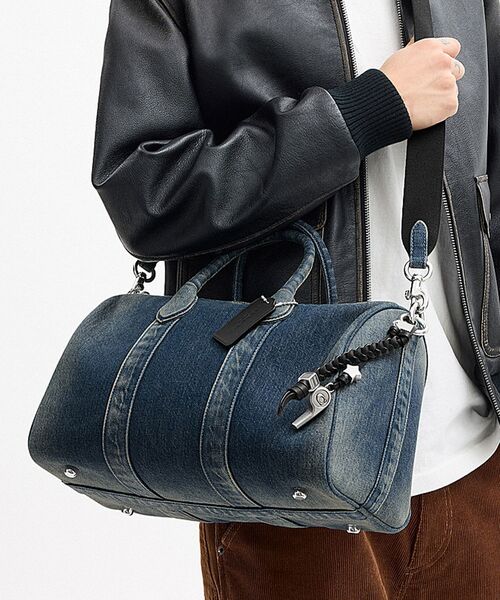 COACH(コーチ)の「コンパス バッグ 35・リジェネラティブ コットン デニム・チャーム(ドラムバッグ・メンズ・ブルー系その他・ONE)」の1枚目の写真