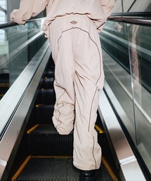 UMBRO（アンブロ）の「UMBRO別注 ドローコードパイピングオーバーサイズカーブナイロントラックパンツ（その他パンツ）」