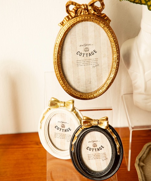 MILLION CARATS（ミリオンカラッツ）の「“リボン×オーバル”《artipur COTTAGE》私らしい思い出を包むフォトフレーム小さなリボンが添える可憐なアクセント。飾るだけで空間が優しく華やぐインテリア毎日の景色に溶け込むサイズ感で、ギフトにもぴったりのクラシカルフレーム 9.5×12.5cm（フォトフレーム・レディース・オフホワイト/ブラック・FREE）」の2枚目の写真