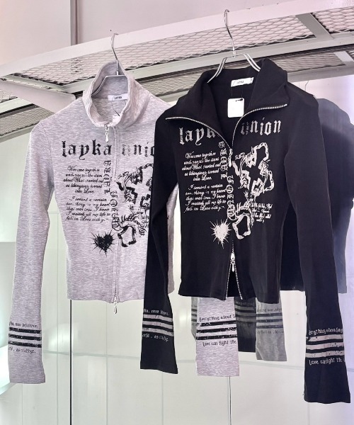 Never mind the XU / Chikashitsu+(ネバーマインド ザ エックスユー / チカシツプラス)の「【BABY09】y2k print slim zipup top / 【ベイビーナイン】ロゴプリントスリムジップアップ長袖Tシャツ(Tシャツ/カットソー・レディース・ブラック/グレー・M)」の1枚目の写真